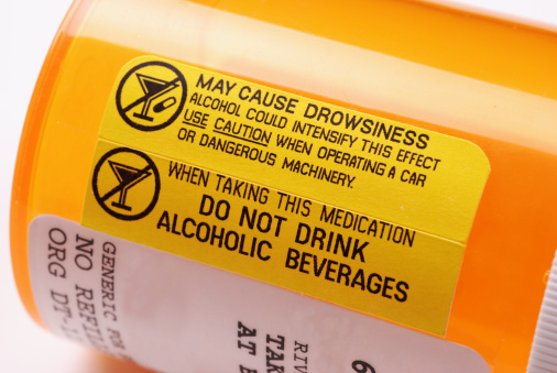 Close-up of a label on a bottle of prescription medication warning not to consume alcohol while using the drug